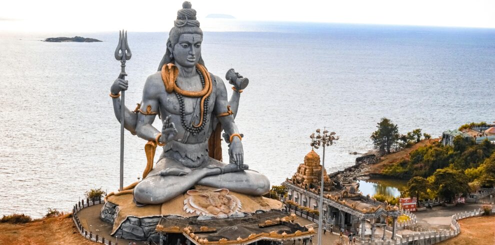 A stunning aerial view of the Murudeshwara Temple with the iconic Shiva statue by the sea.