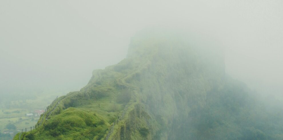 Explore the mystical fog-covered alpine fortress landscapes of Maharashtra, India during monsoon.