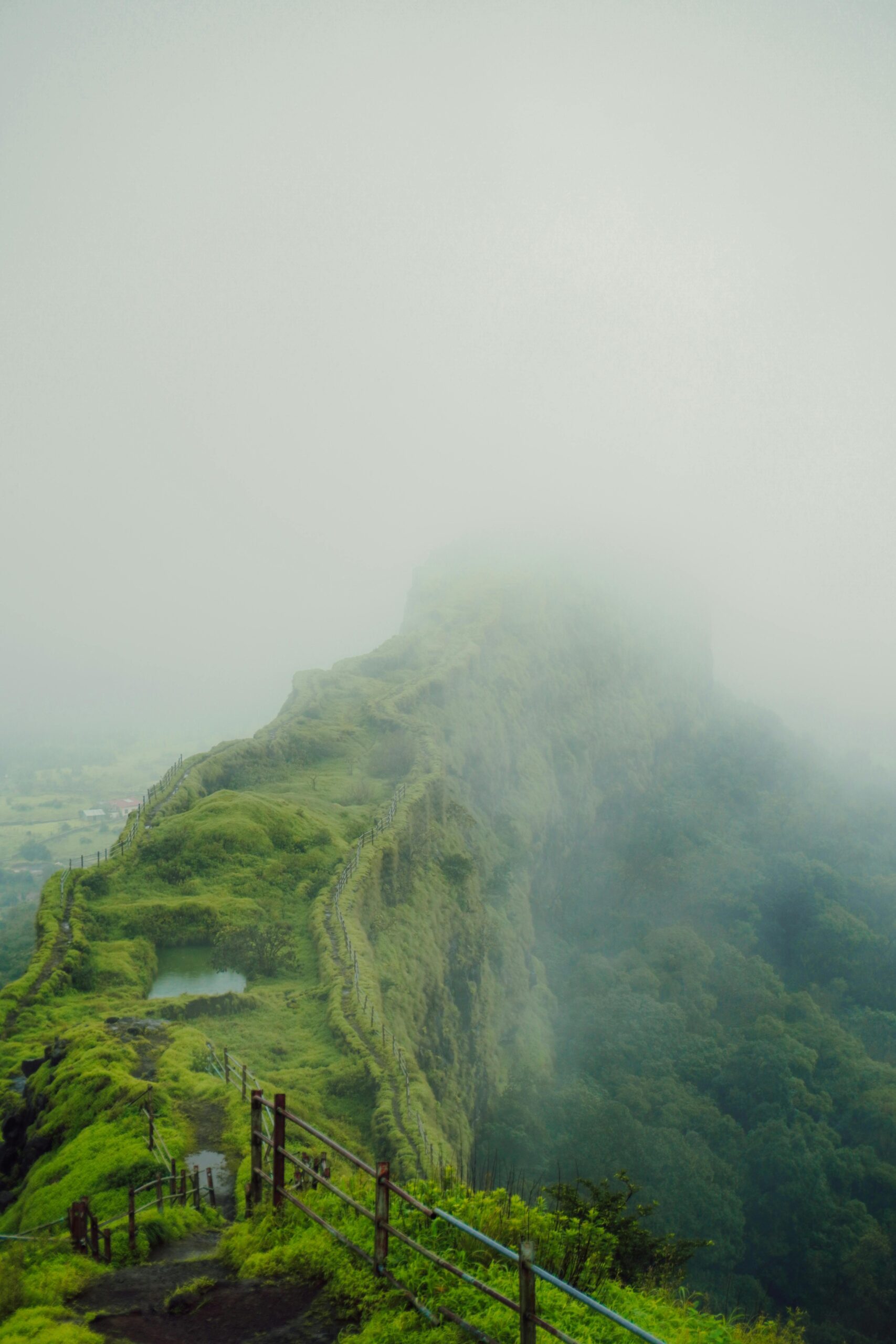 Explore the mystical fog-covered alpine fortress landscapes of Maharashtra, India during monsoon.