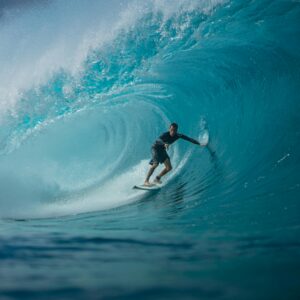 A surfer skillfully rides a massive ocean wave, capturing the thrill and essence of water sports.